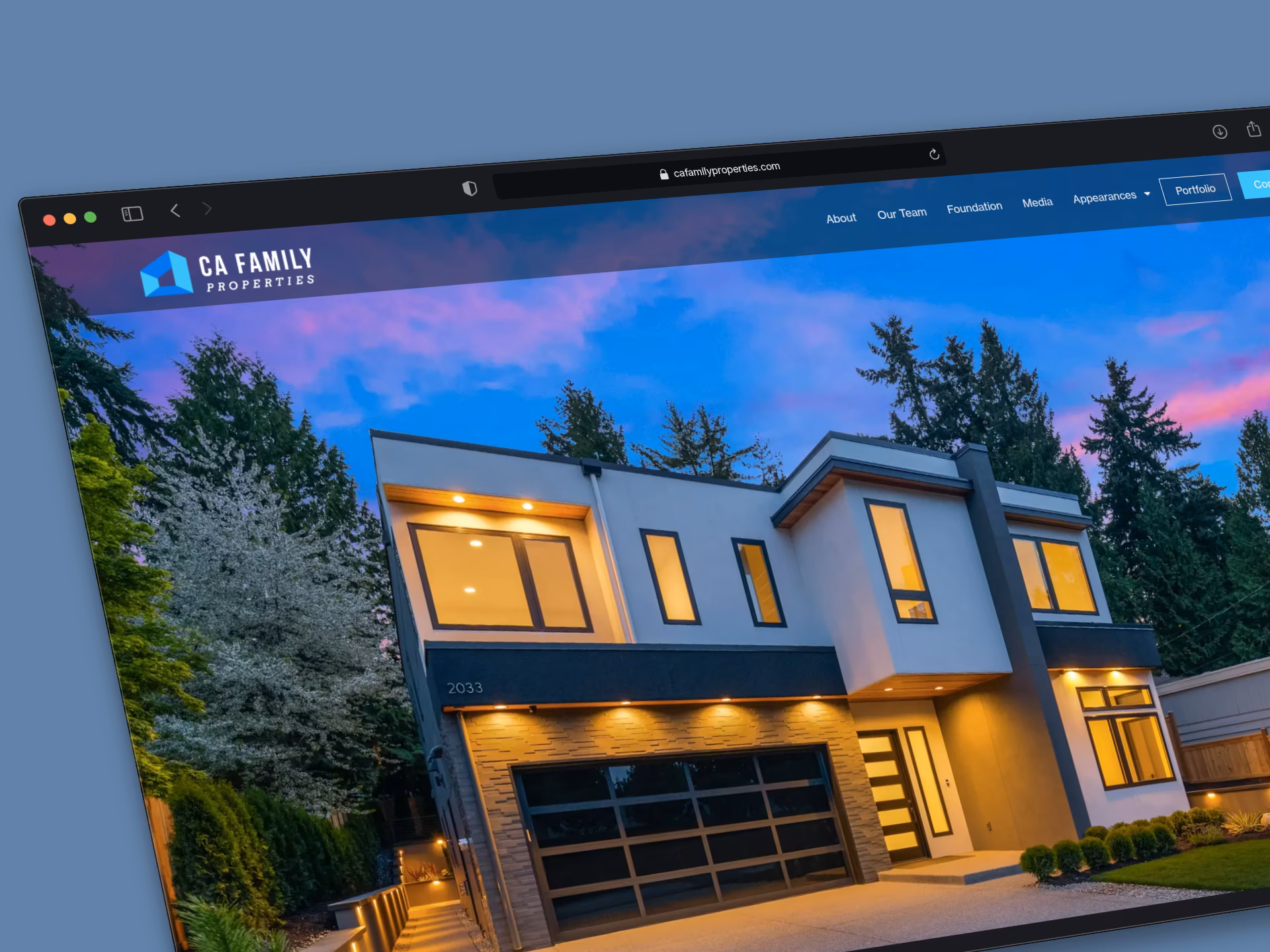 The CA Family Properties homepage on a laptop, a modern home lit at dusk