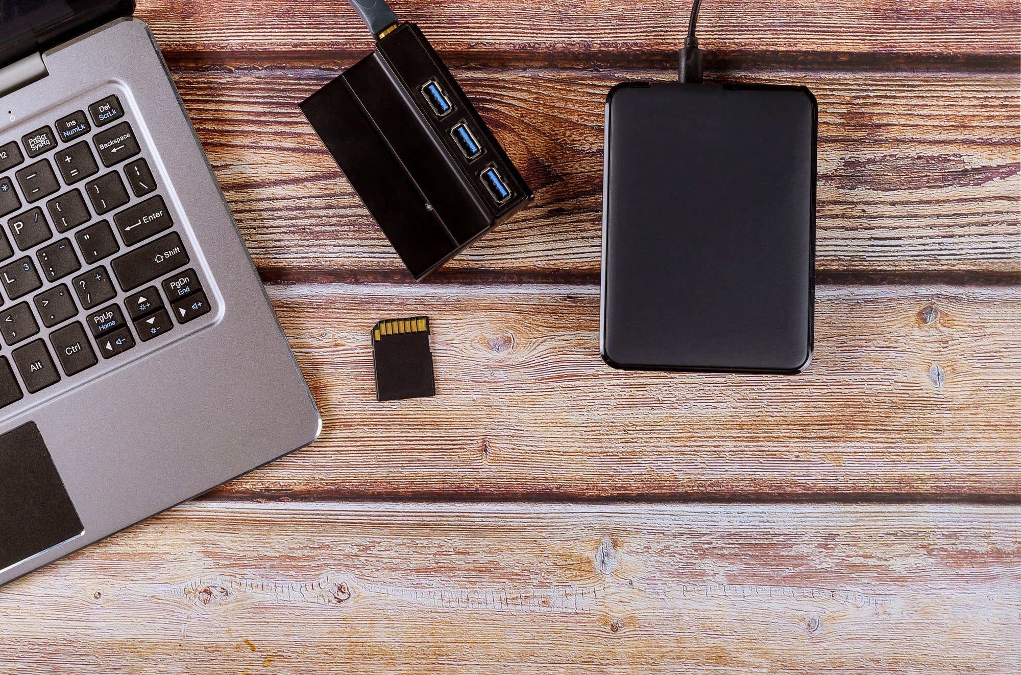 Photographers desktop workspace external backup disk hard drive connected to laptop computer